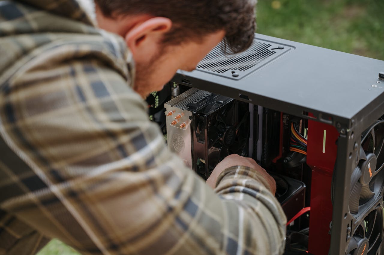 our-services-1 A man cleans and maintains a desktop PC outdoors with precision.
