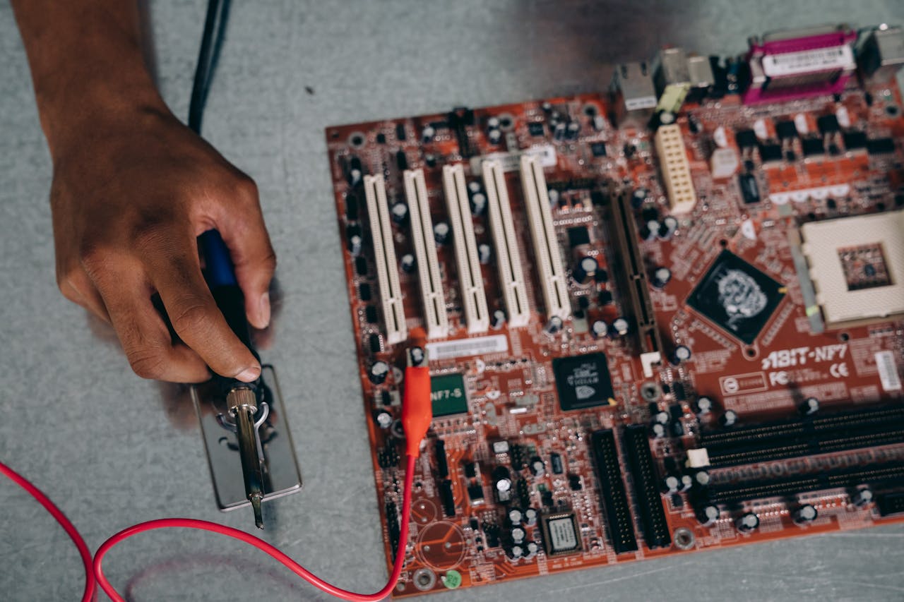 gallery-6 An engineer uses a soldering tool on a motherboard, showcasing technology and precision.